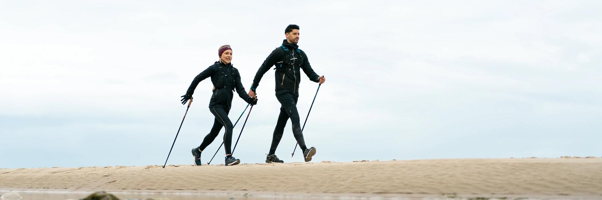 Para uprawiająca nordic walking na plaży