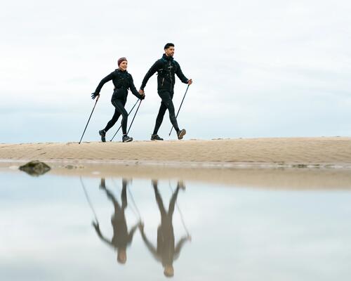Para uprawiająca nordic walking na plaży