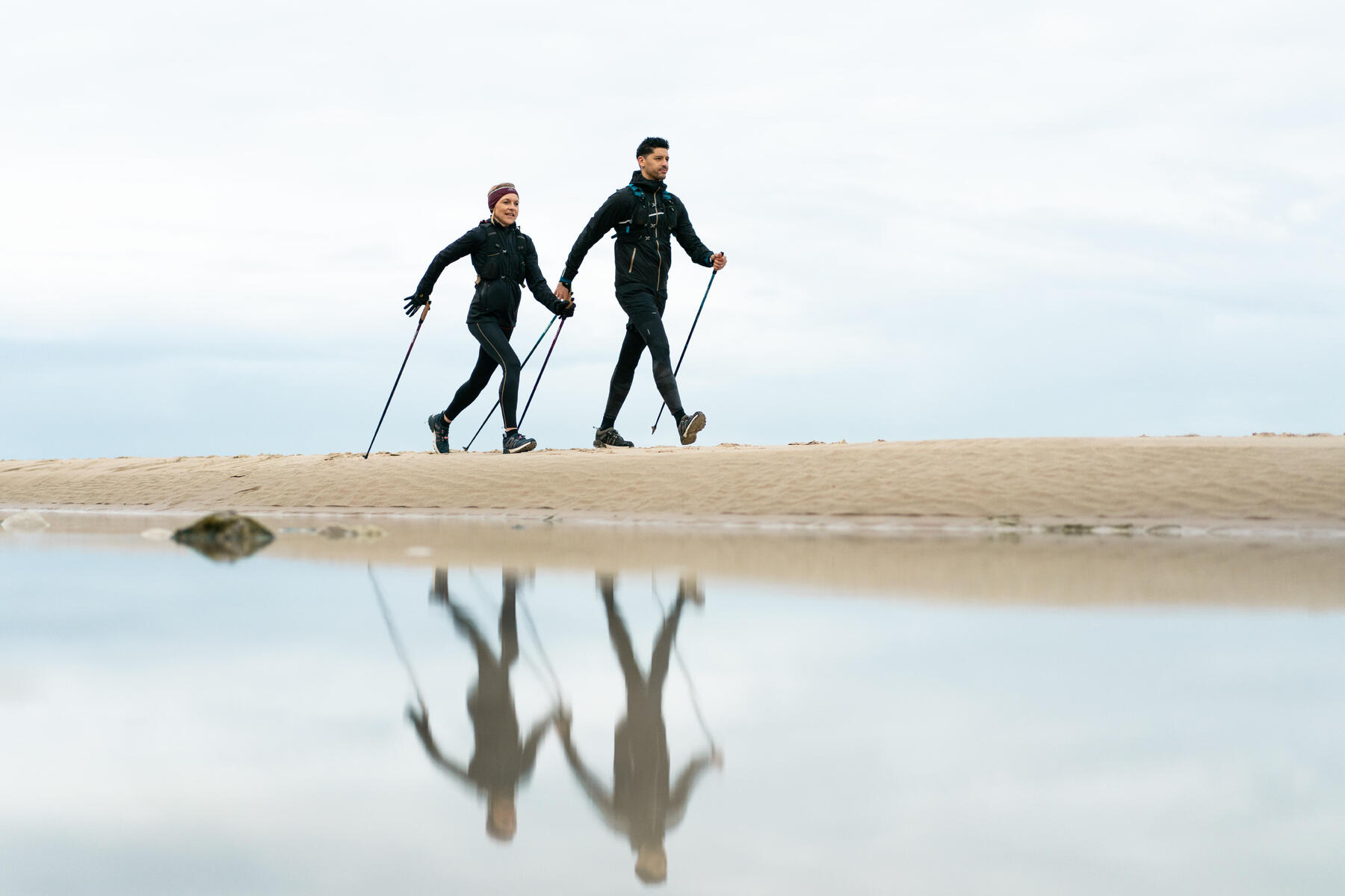 Para uprawiająca nordic walking na plaży