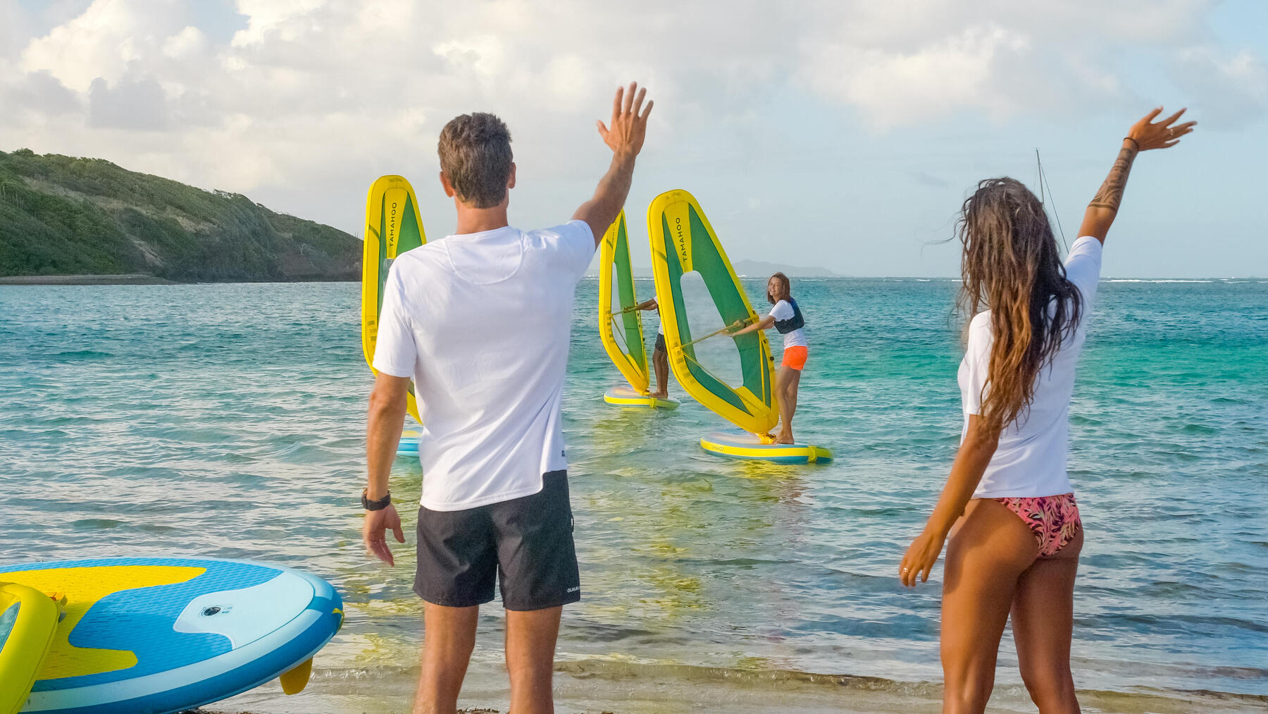 Kobieta i mężczyzna machający do znajomych na windsurfingu