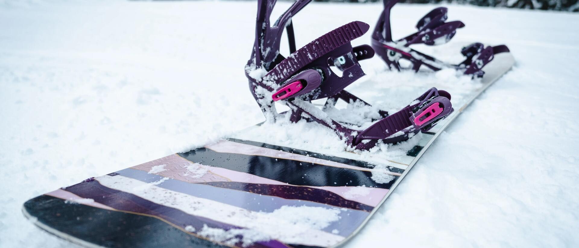 deska snowboardowa z wiązaniami leżąca na śniegu