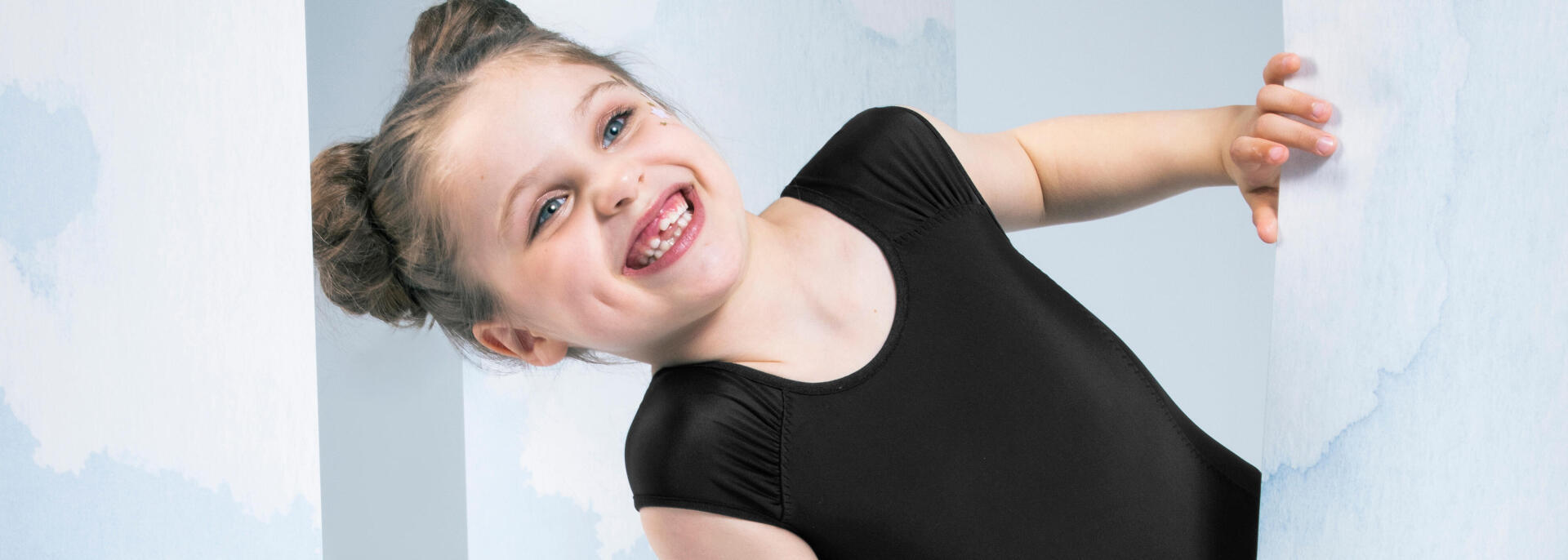little girl smiling in a bodysuit for gymnastics