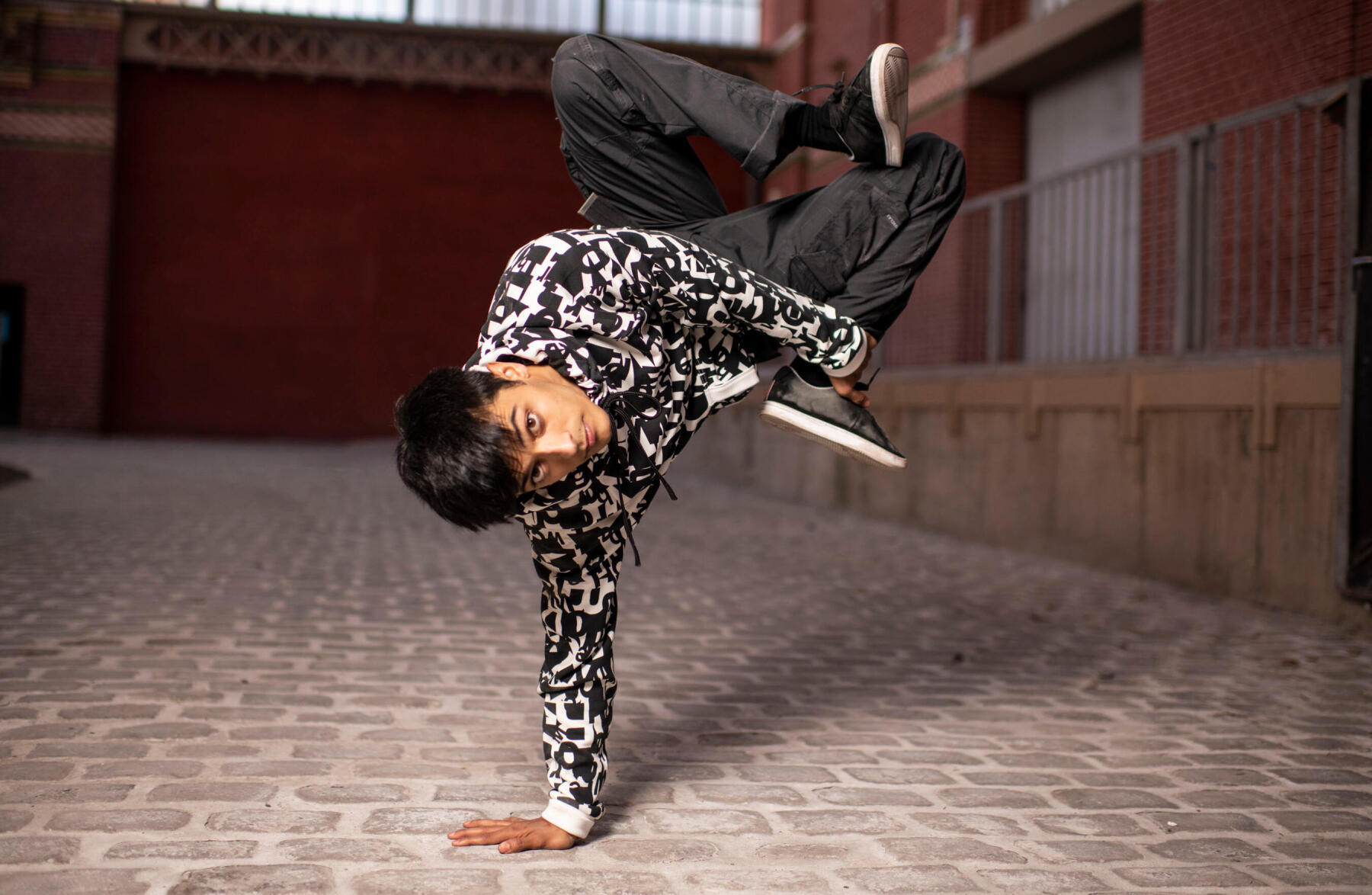 A boy presenting a dance choreography in an alley