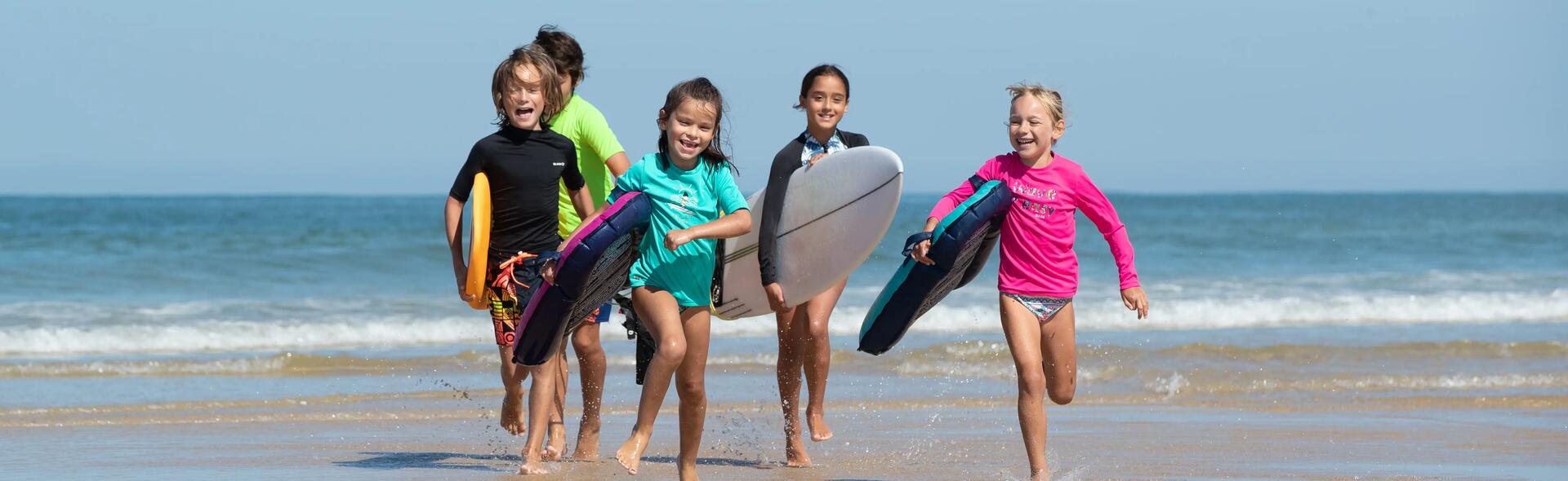 crianças na praia com t-shirt UV