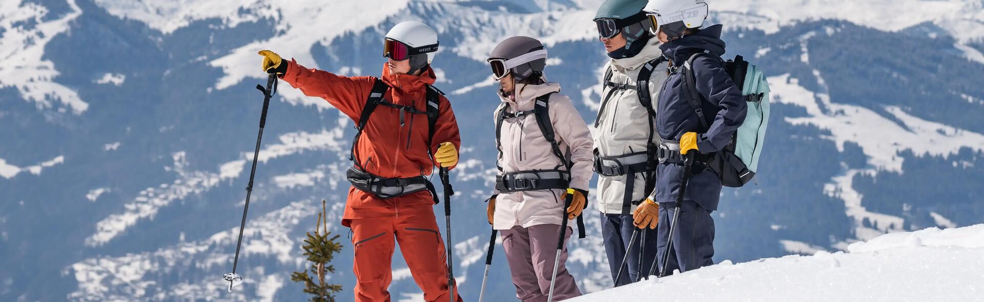 ludzie w strojach narciarskich z plecakami stoją w górach 