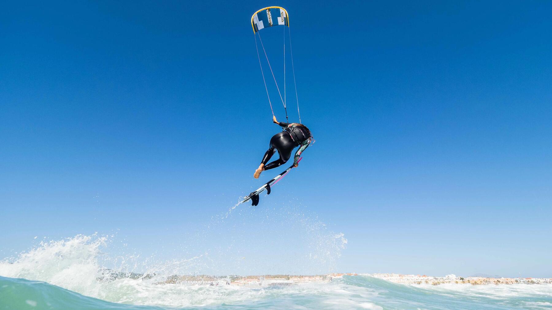 Kitesurferka wykonująca triki na desce kitesurfingowej wykorzystując okno wiatrowe