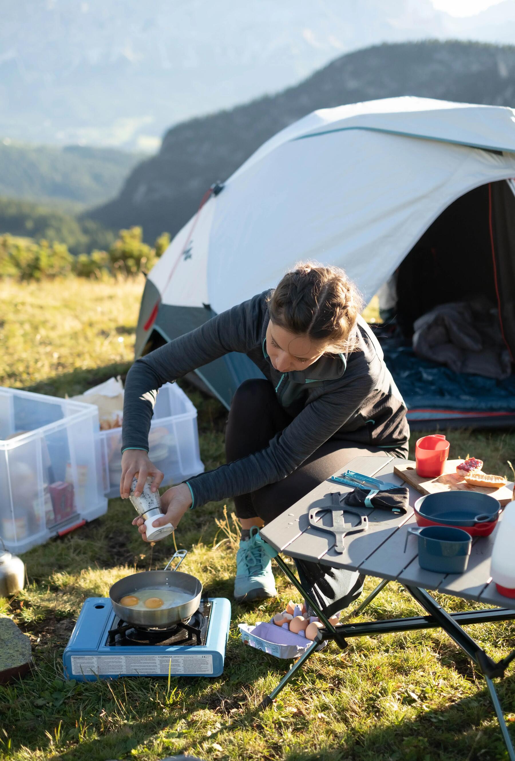 mulher a cozinhar no campismo decathlon