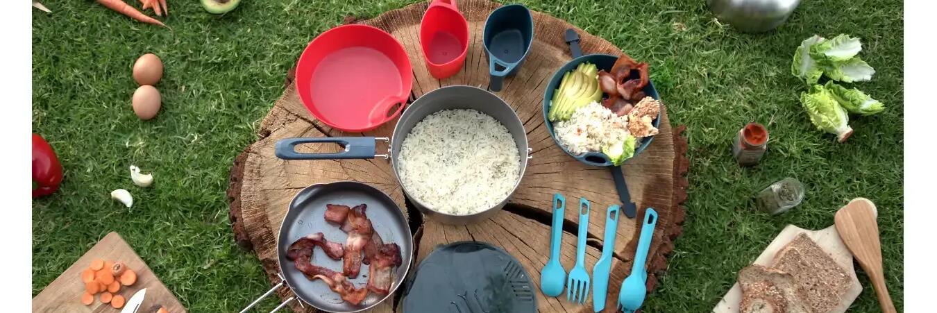 Das richtige Campinggeschirr liegt auf einem Holztisch