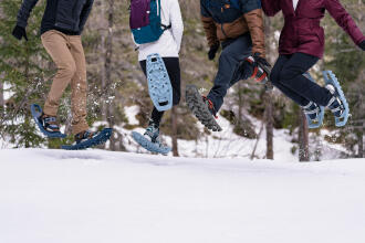 people jumping while wearing snowshoes