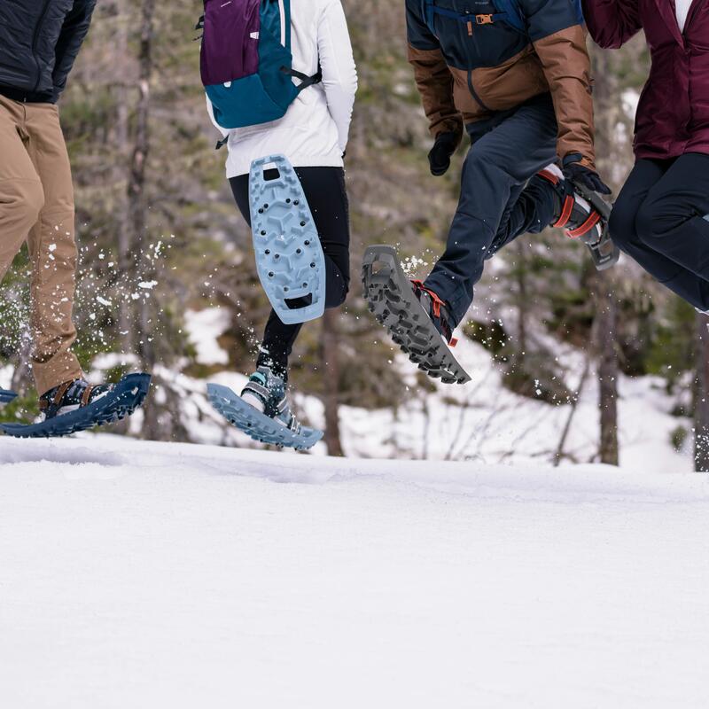 people jumping while wearing snowshoes