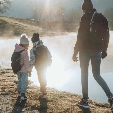 A family of three taking a walk in the fog in waterproof hiking jackets