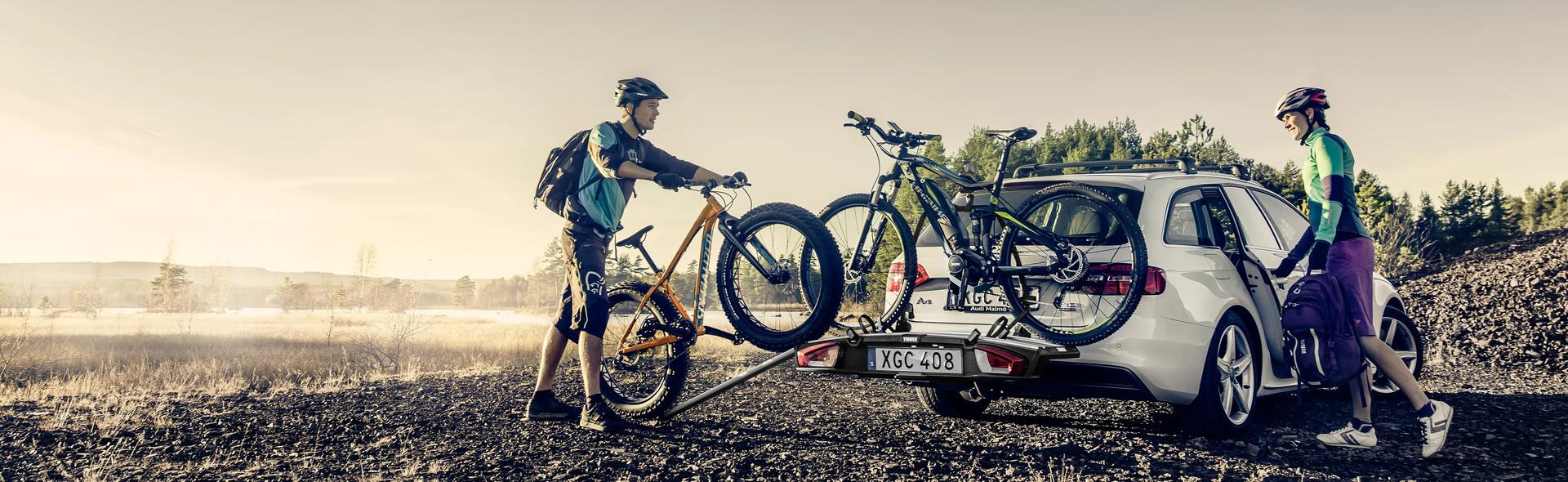 Una coppia carica le bici sul portabici da gancio traino