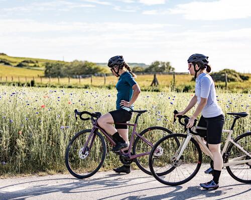 women cycling along fields