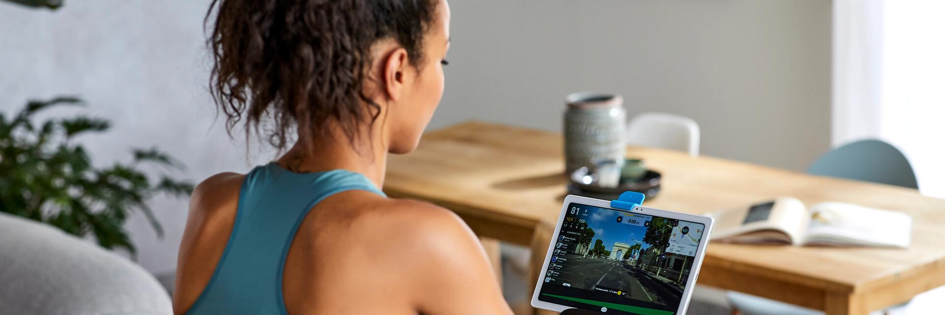 Een vrouw aan een hometrainer in haar woonkamer
