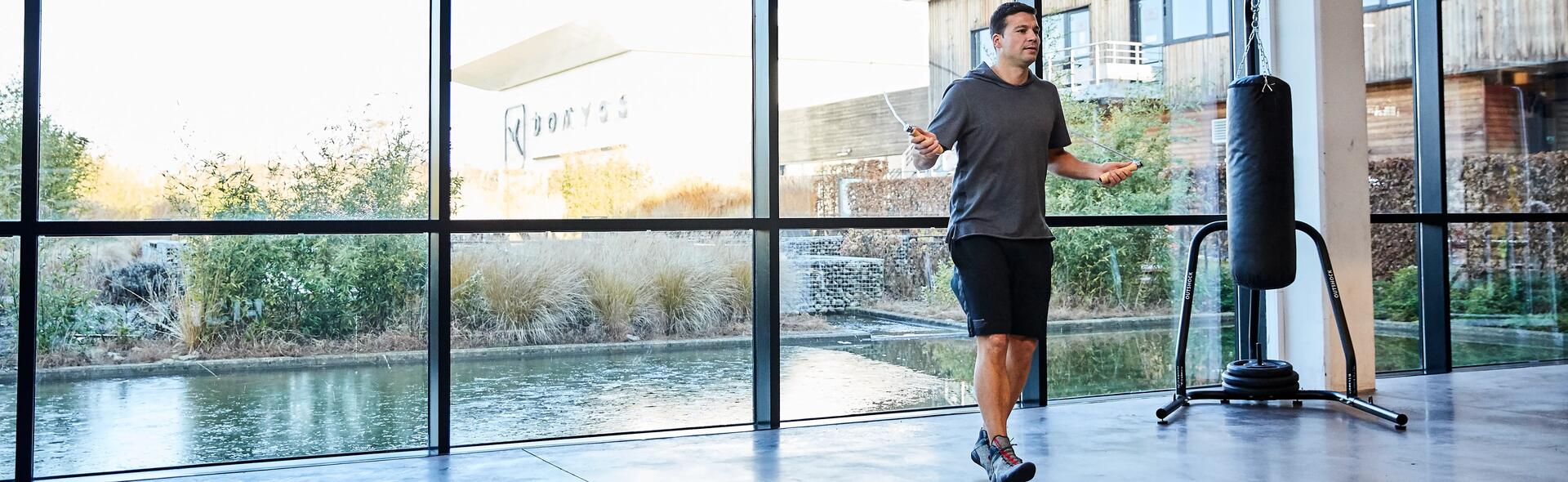 Man using skipping rope indoors.