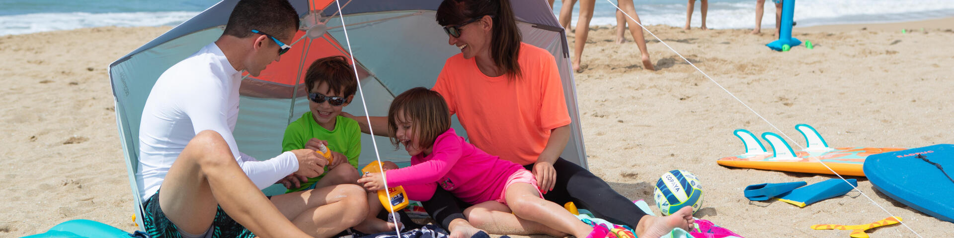 Familia na areia/praia, no guarda sol