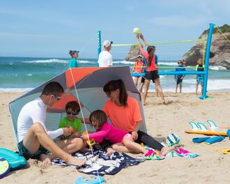 Familia na areia/praia, no guarda sol