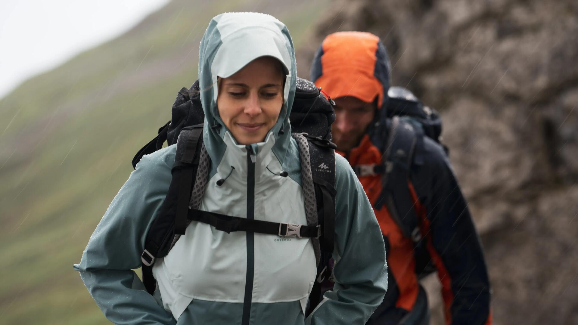 femme et homme en randonnée sous la pluie