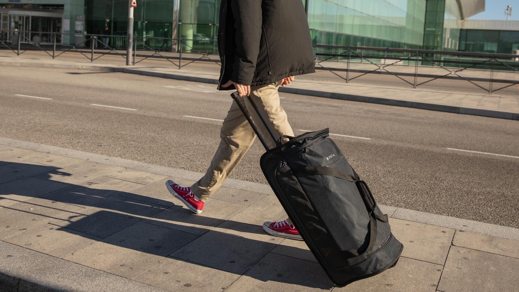 Frau zieht Trolley Bag hinter sich her