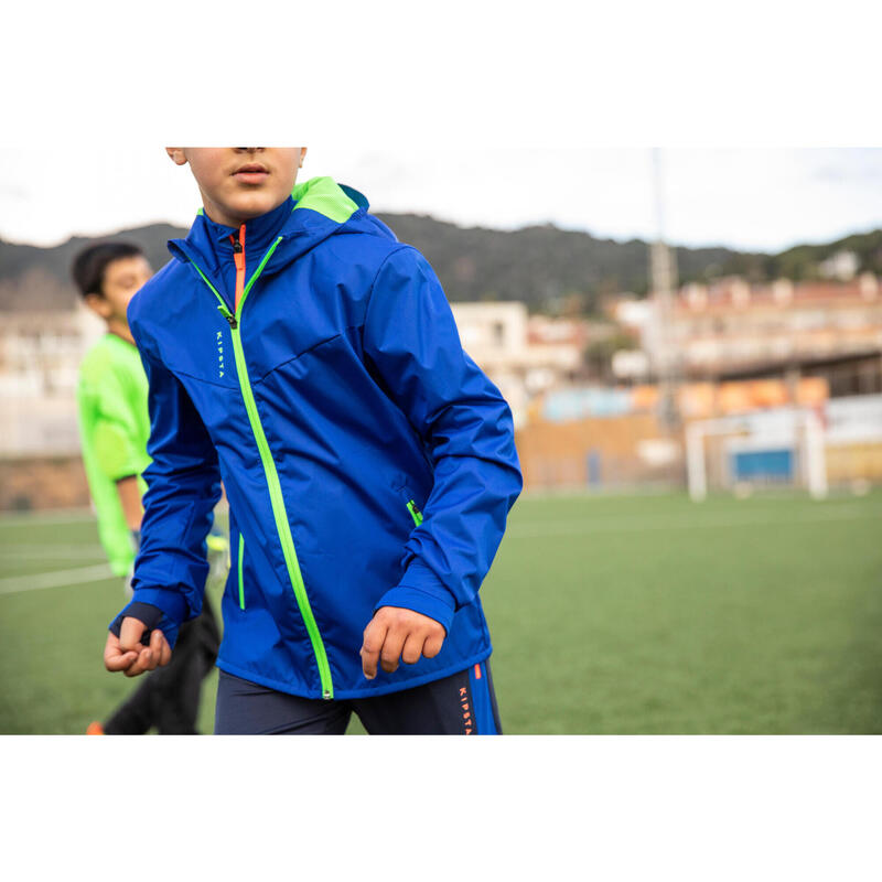 Dětská fotbalová bunda do deště T500 modrá se zeleným fluorescenčním zipem