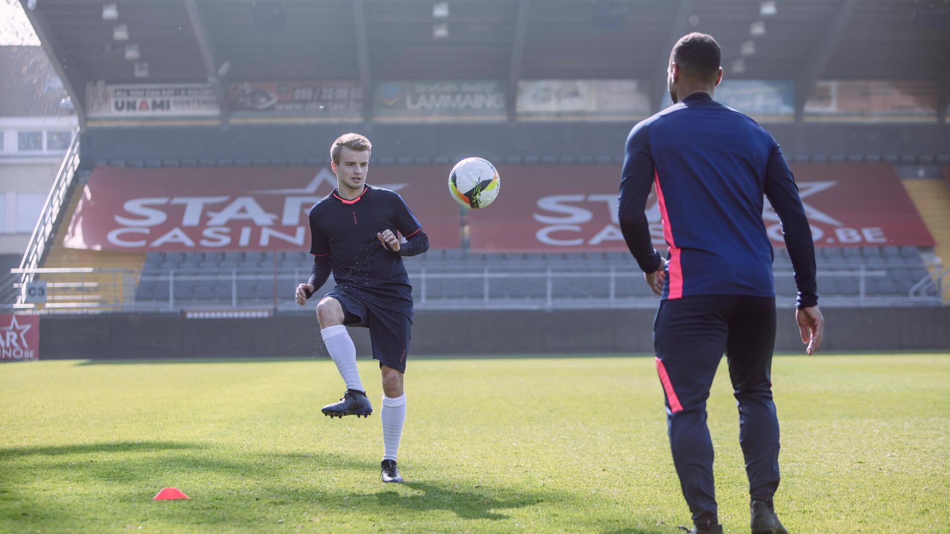 2 men playing football in a stadium