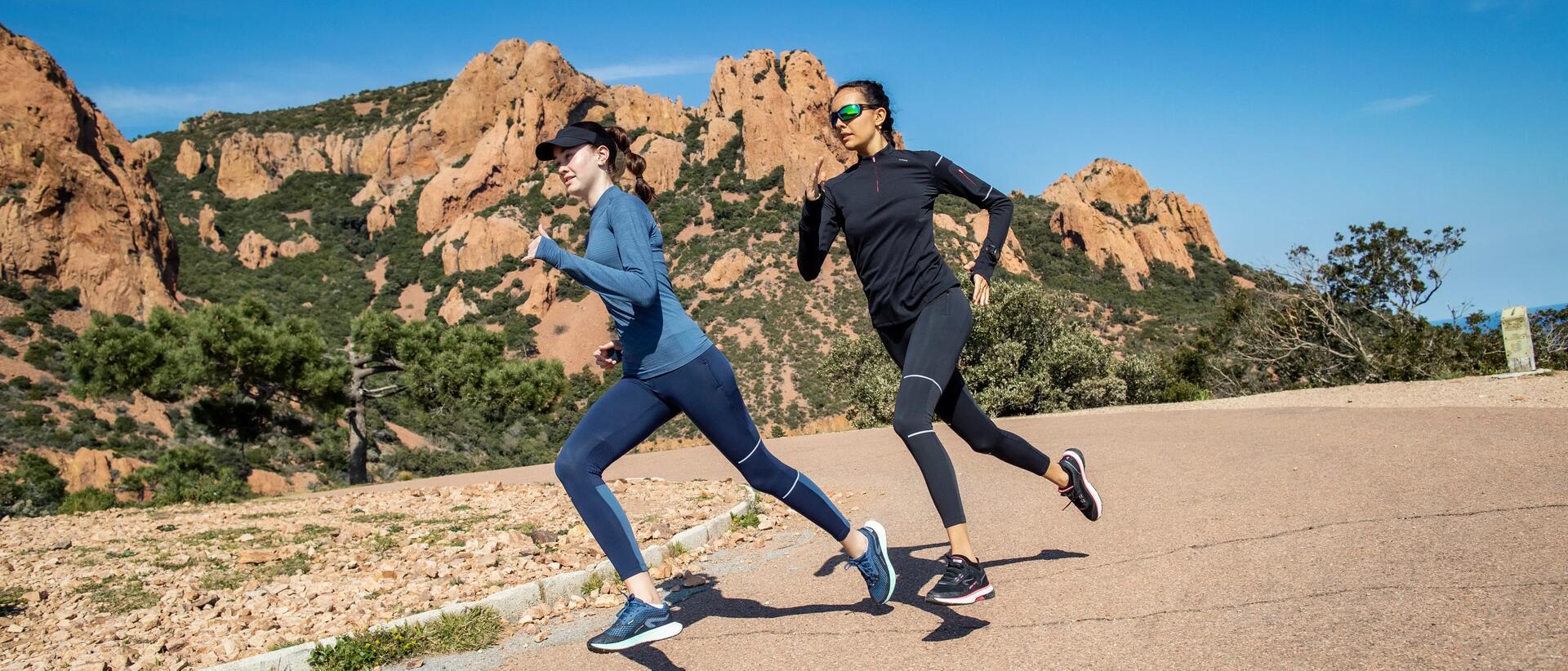 Homem e mulher a correr junto a um rio, perto de uma cidade.