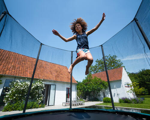 dziewczynka skacząca na trampolinie ogrodowej