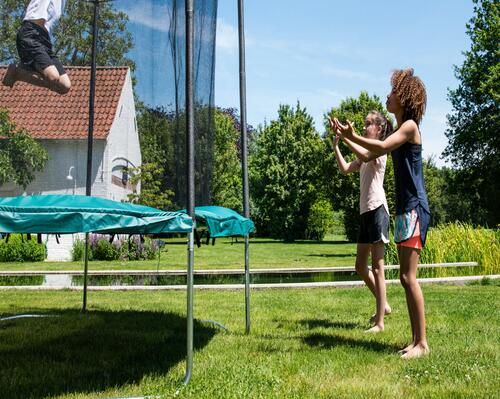 Kinder auf dem Trampolin in freier Natur beim Turnen und Spielen