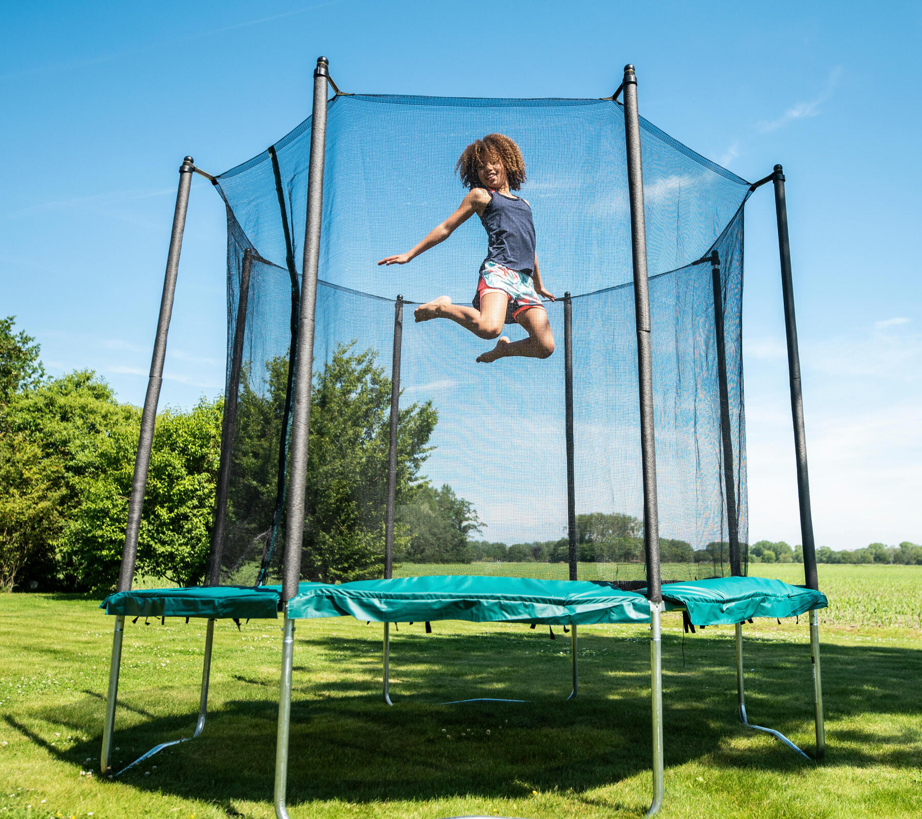 crianca a saltar em trampolim da decathlon no jardim