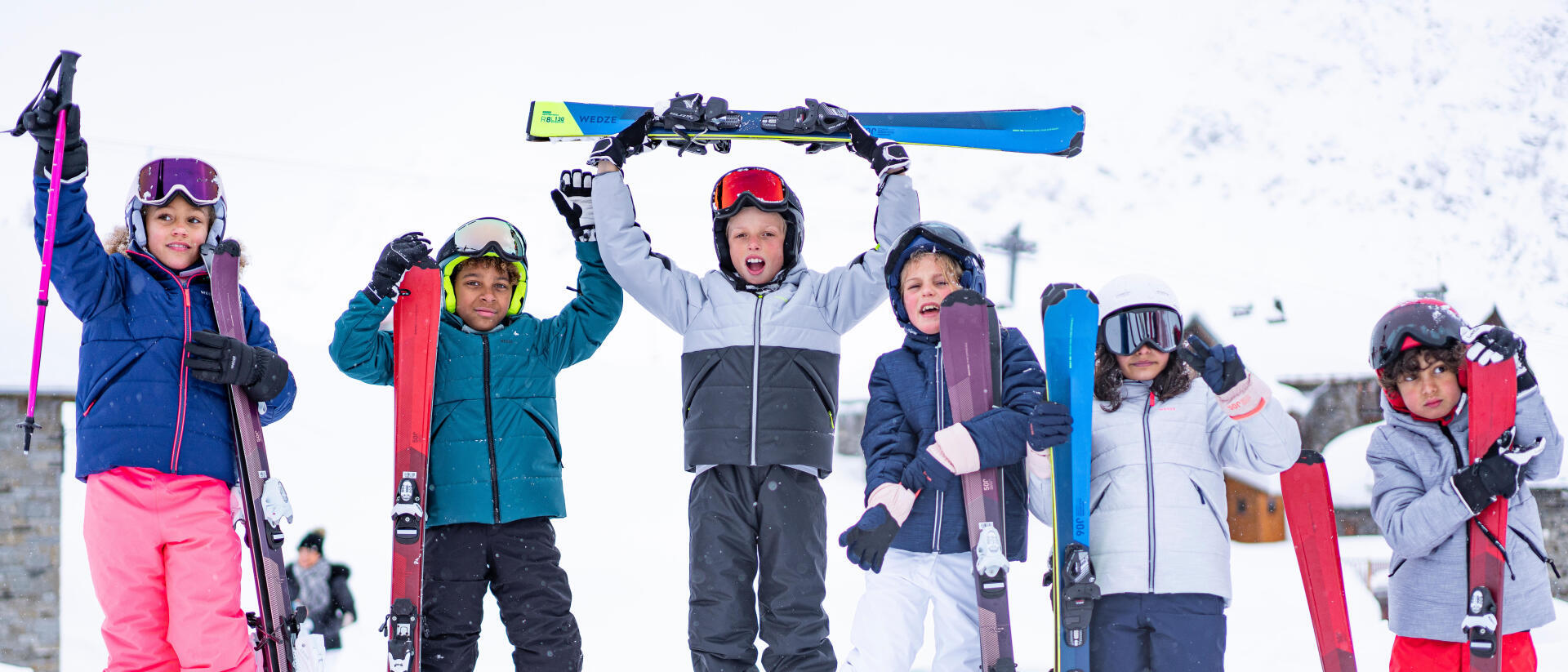 Barn som står med skidor i snön