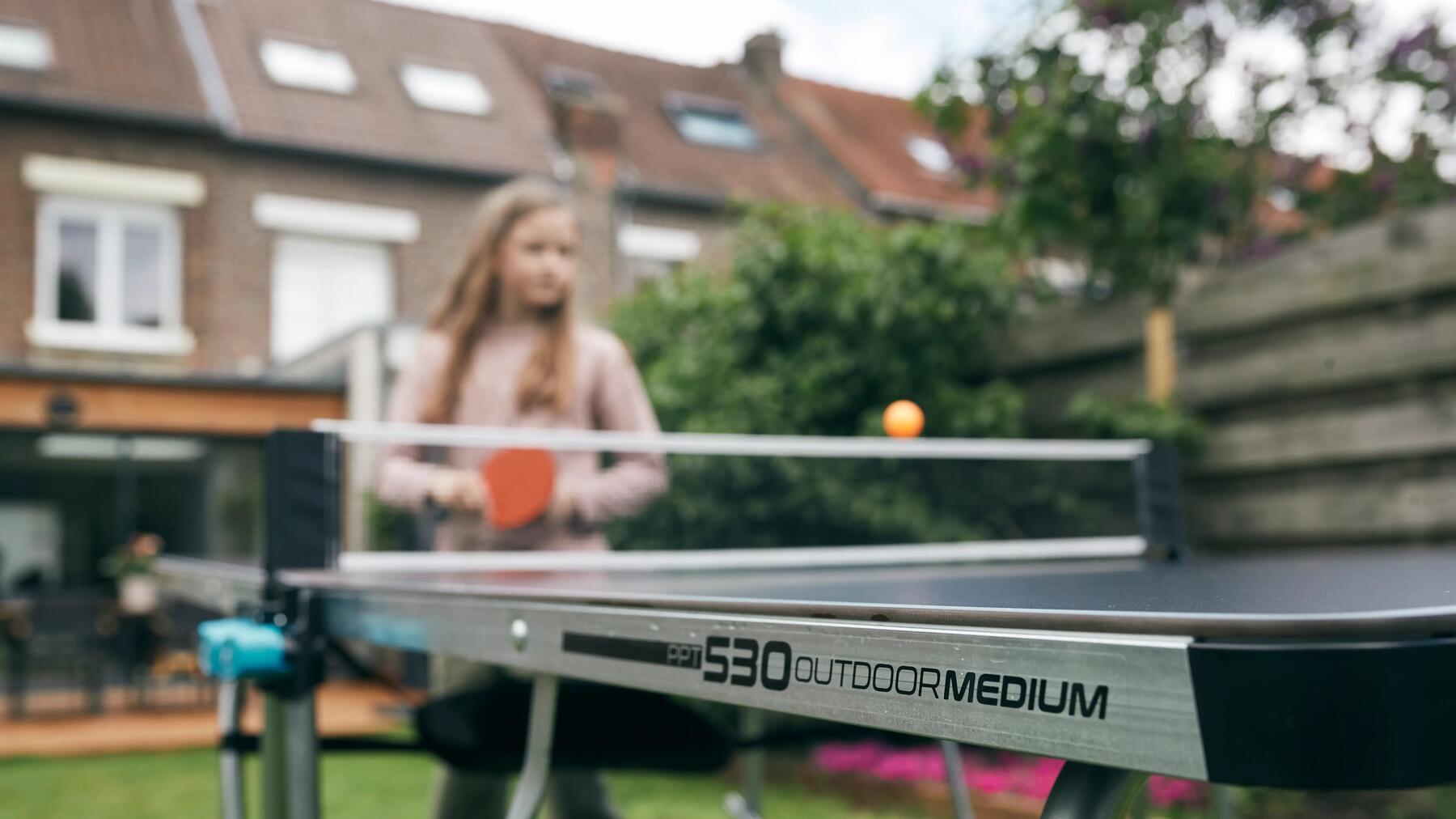 Mädchen spielt an Tischtennisplatte