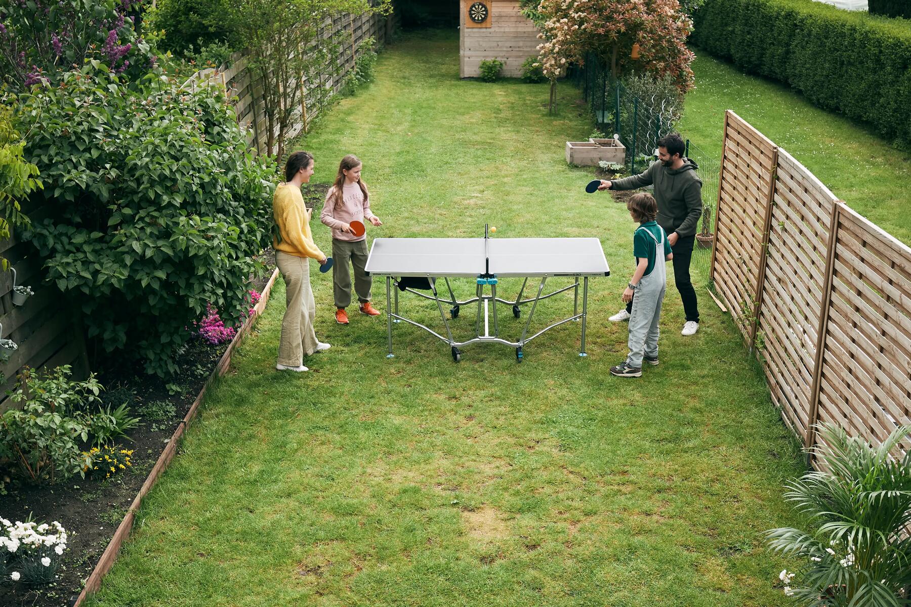 Familie steht um eine Tischtennisplatte