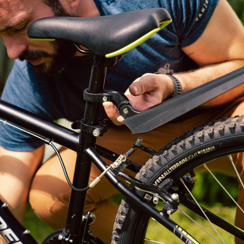 Father attaching mudguard on his kid's bike.