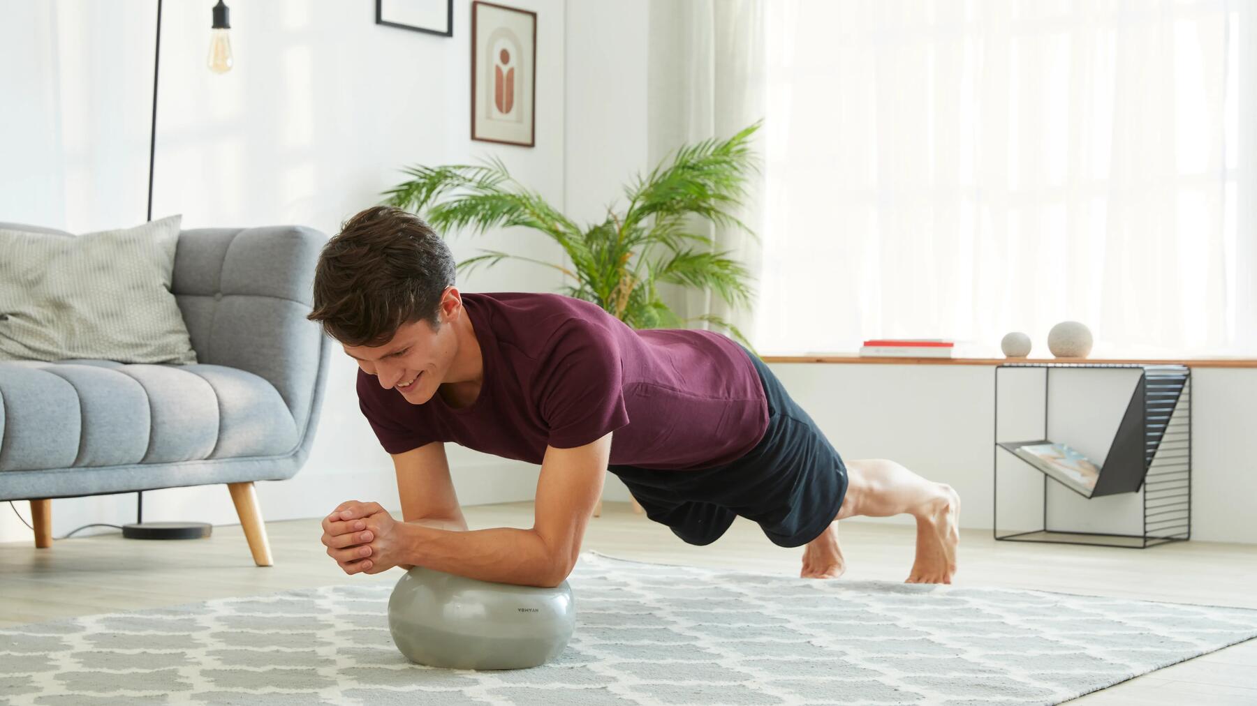 hombre haciendo planchas sobre balón medicinal