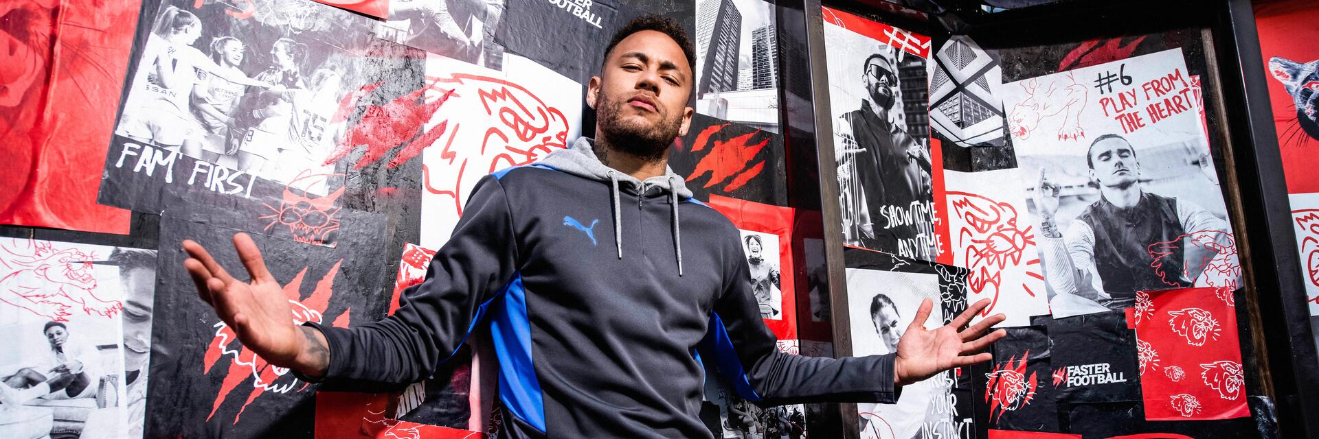 PIłkarz Neymar będący rekordzistą najdroższego transferu piłkarskiego w historii stojący z rozłożonymi rękami w stroju sportowym 