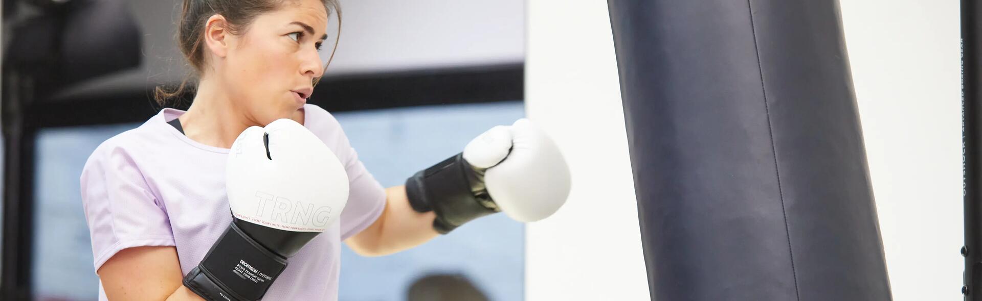 kobieta w rękawicach bokserskich ćwicząca z workiem treningowym