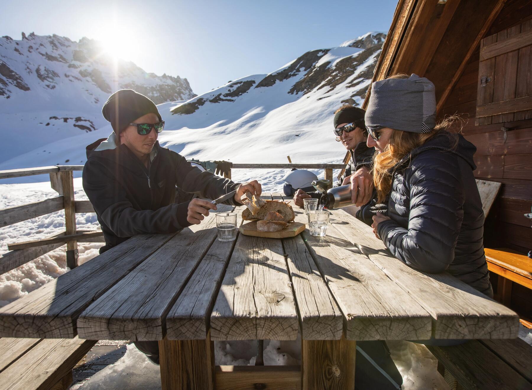 Narciarze spożywający posiłek podczas przerwy w jeździe na nartach