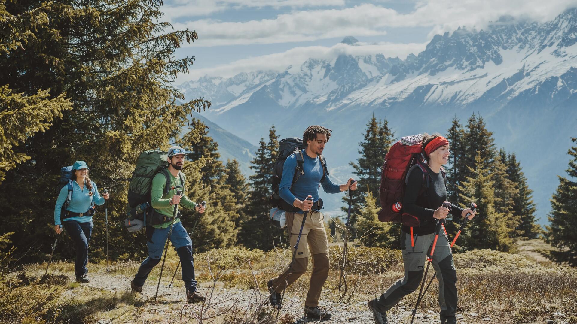 4 people hiking on track, in line