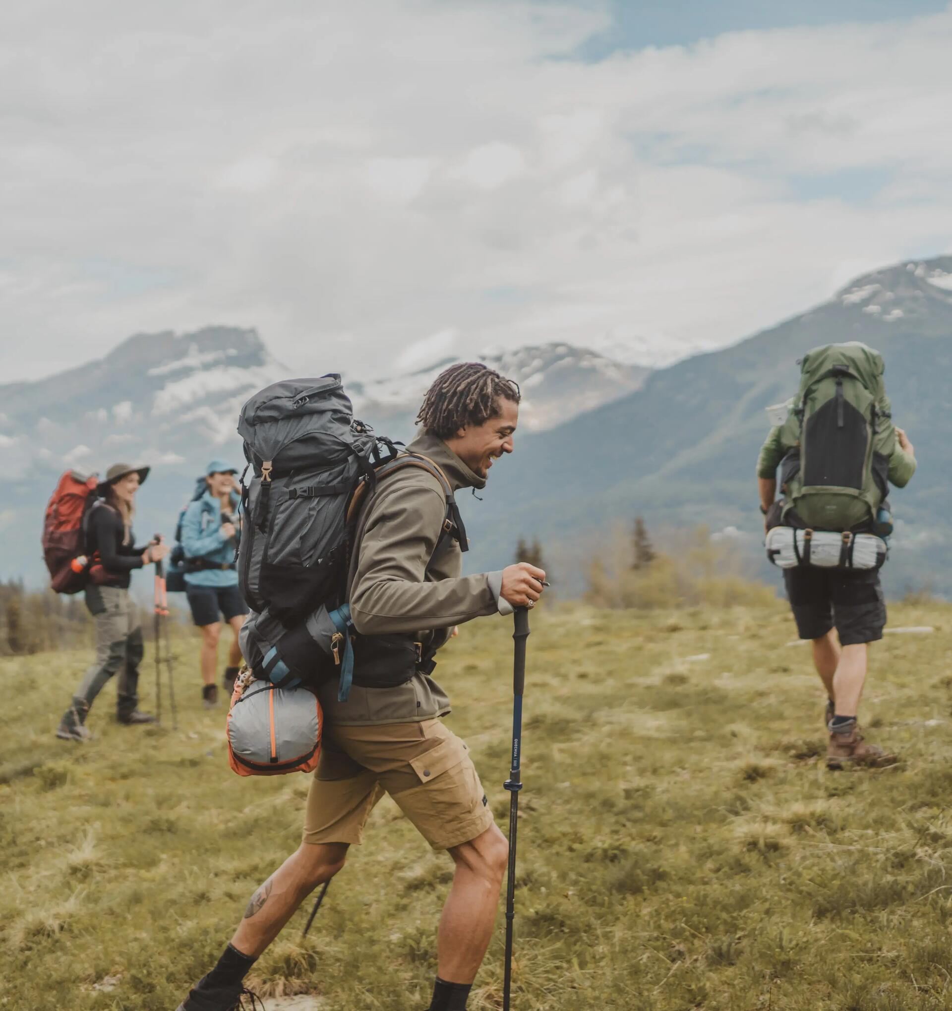 Four backpackers walking towards the mountains