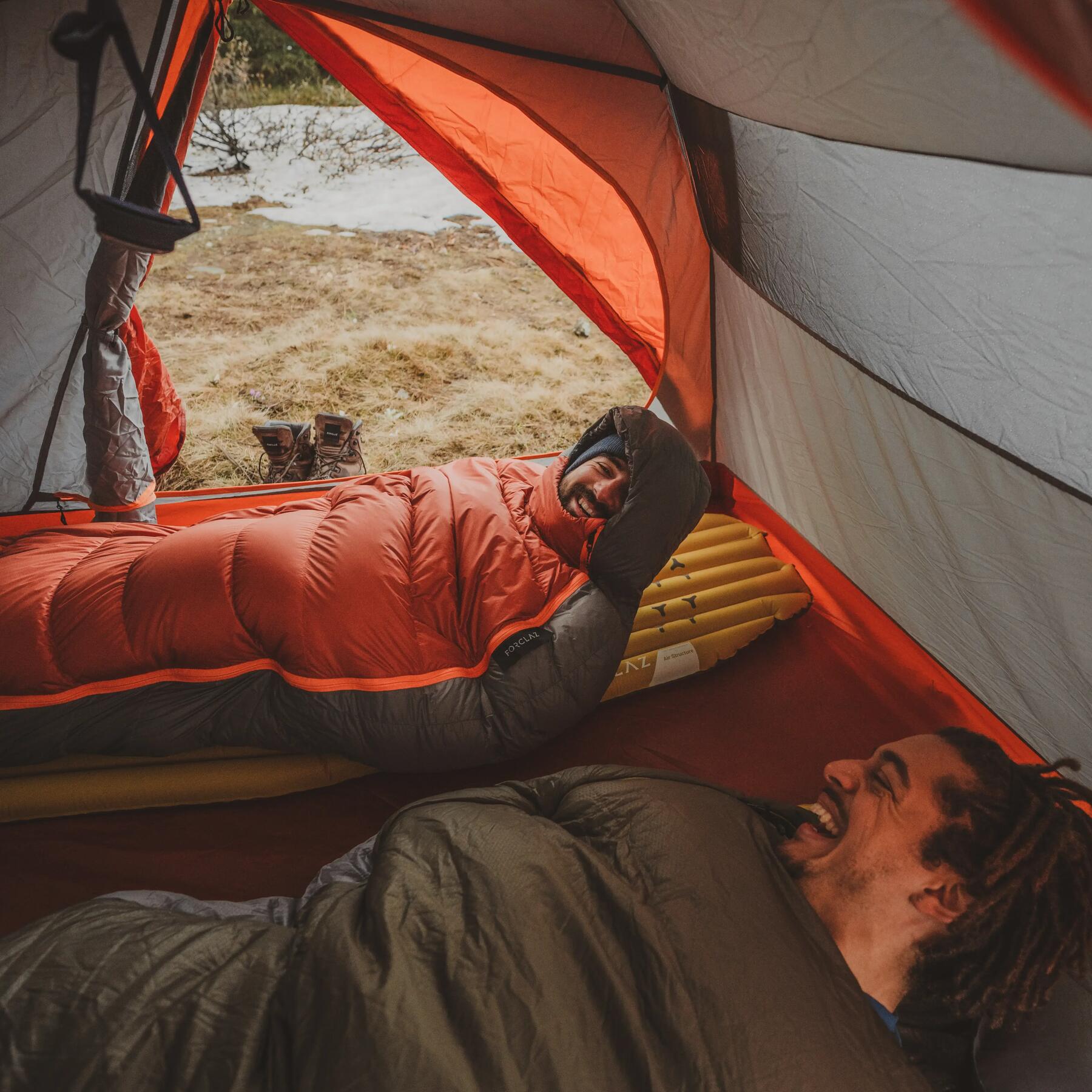 Man sleeping soundly on a camp bed  inside a tent