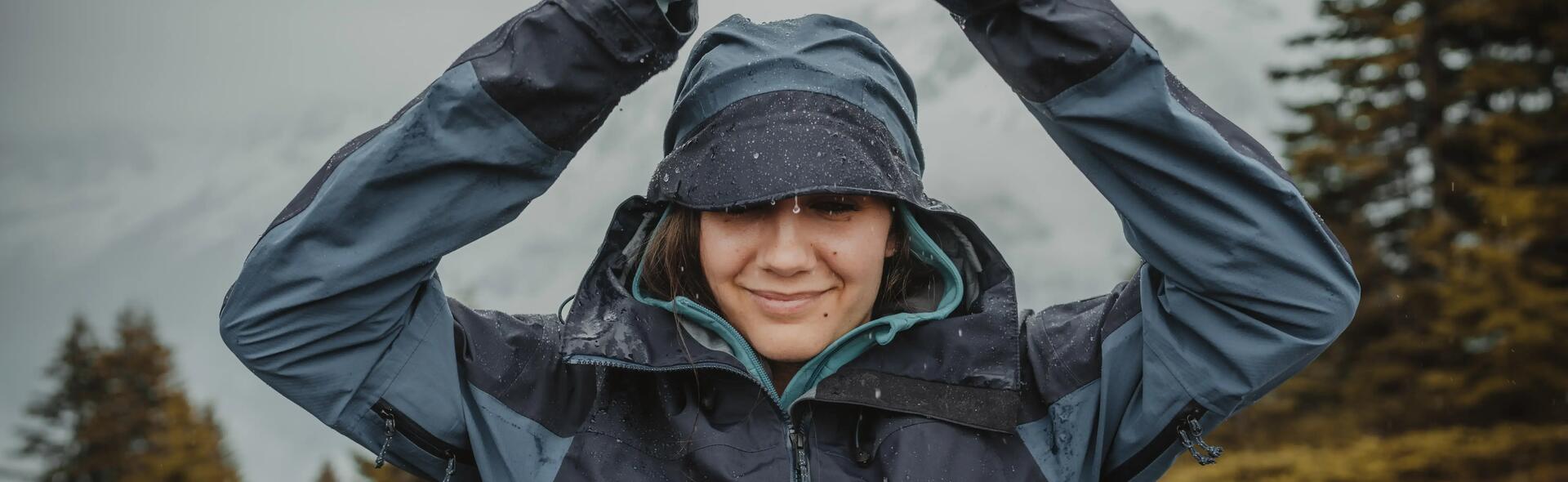 woman smiling in the rain wearing a rain jacket
