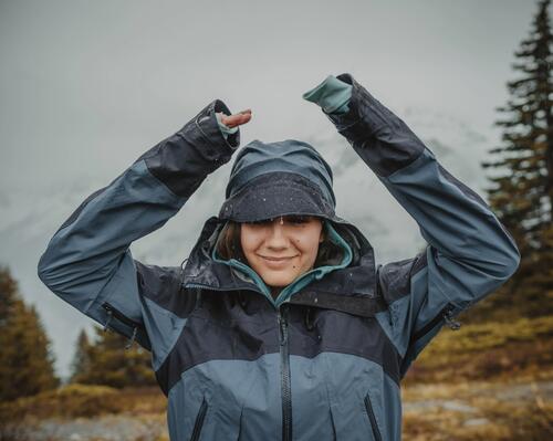 woman smiling in the rain wearing a rain jacket