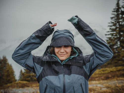 woman smiling in the rain wearing a rain jacket