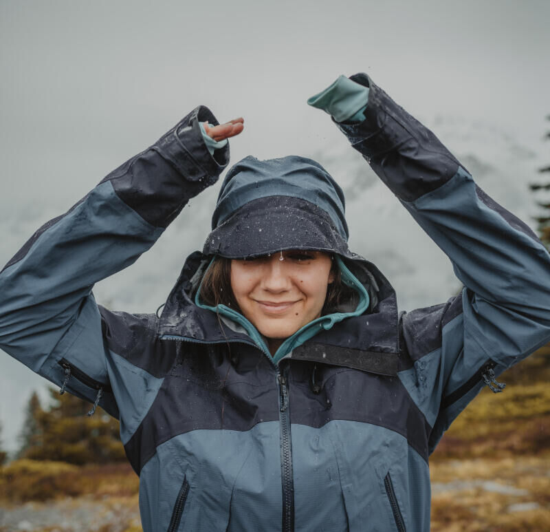 woman smiling in the rain wearing a rain jacket