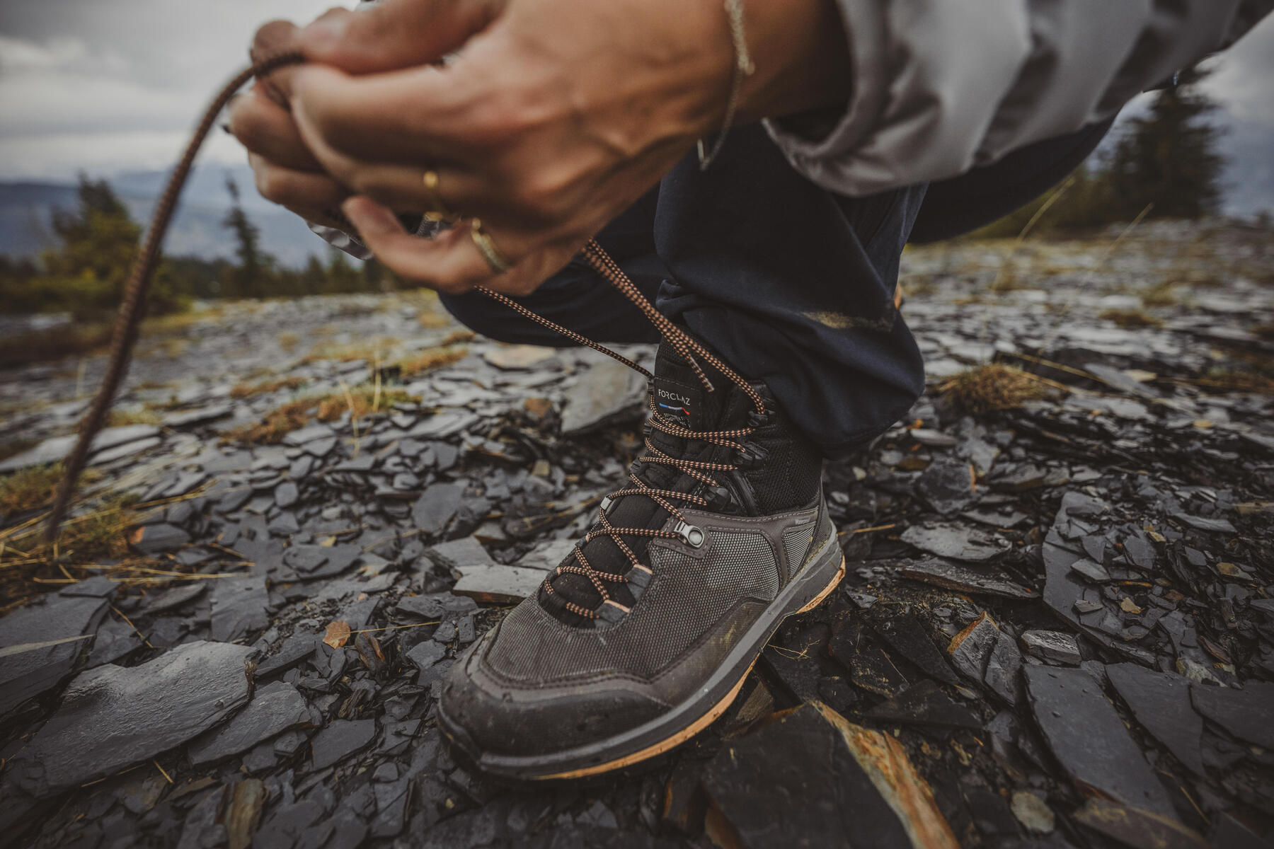 Mężczyzna wiążący buty trekkingowe na krzyż