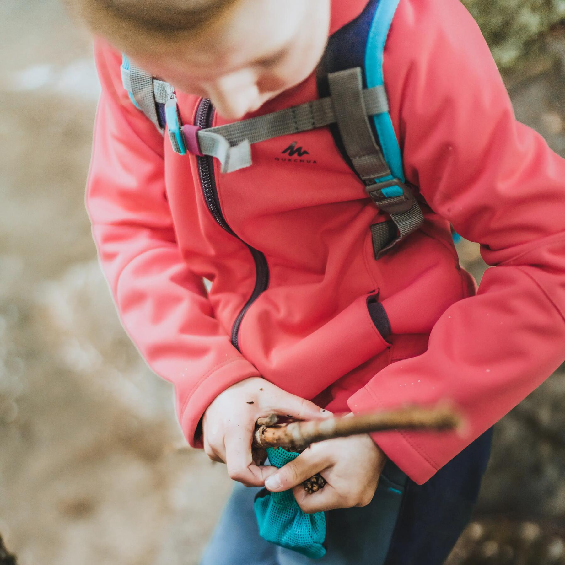 Enfant en randonnée qui collectionne des petits objects naturels