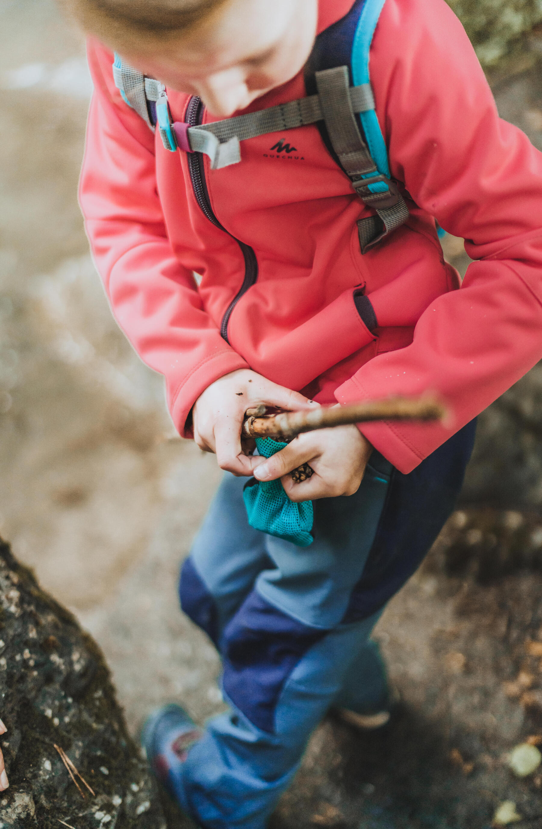 Enfant en randonnée qui collectionne des petits objects naturels