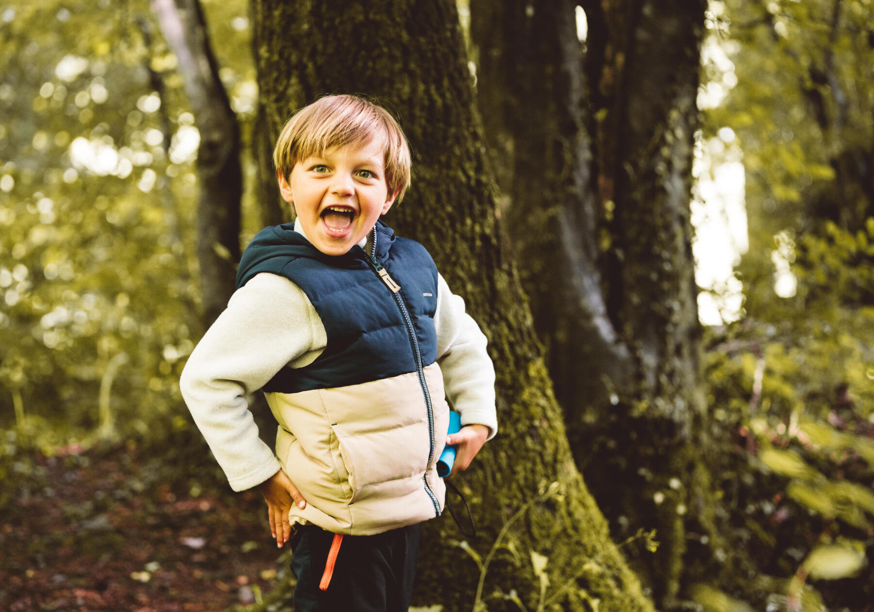 Enfant qui prend la pose pendant une randonnée en forêt