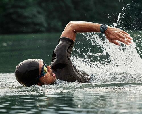 mężczyzna płynący w czepku i okularach pływackich ze smartwatchem na ręce