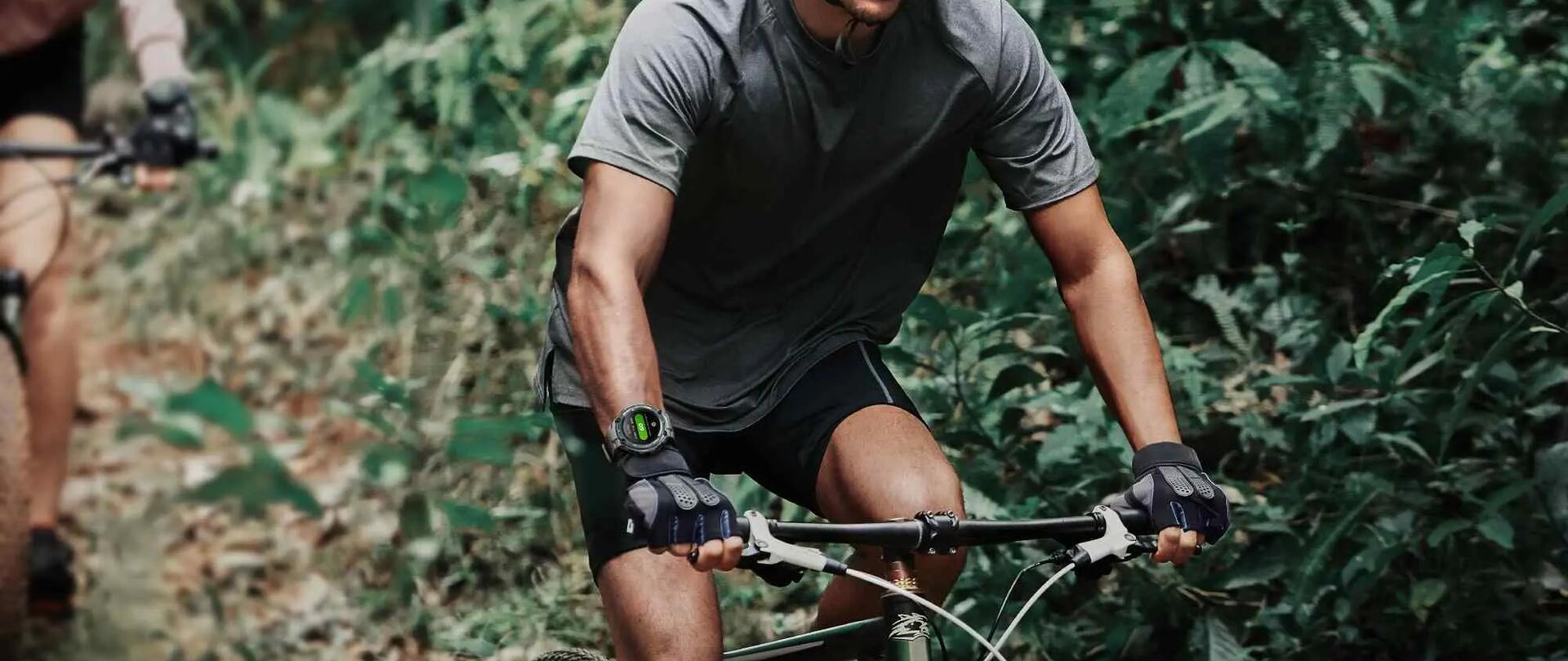 Mężczyzna jadący na rowerze z zegarkiem sportowym na ręce